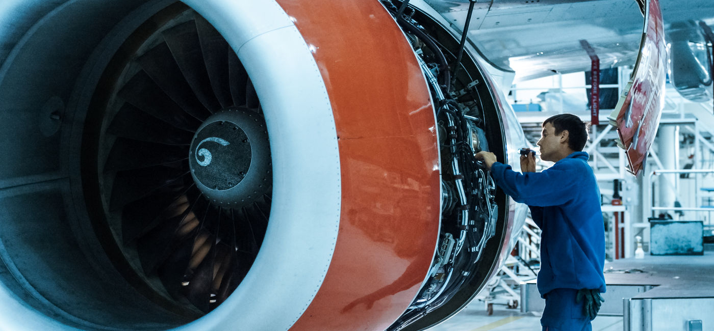 Image: Airplane mechanic inspects plane engine. (photo via iStock / Getty Images Plus / gorodenkoff)